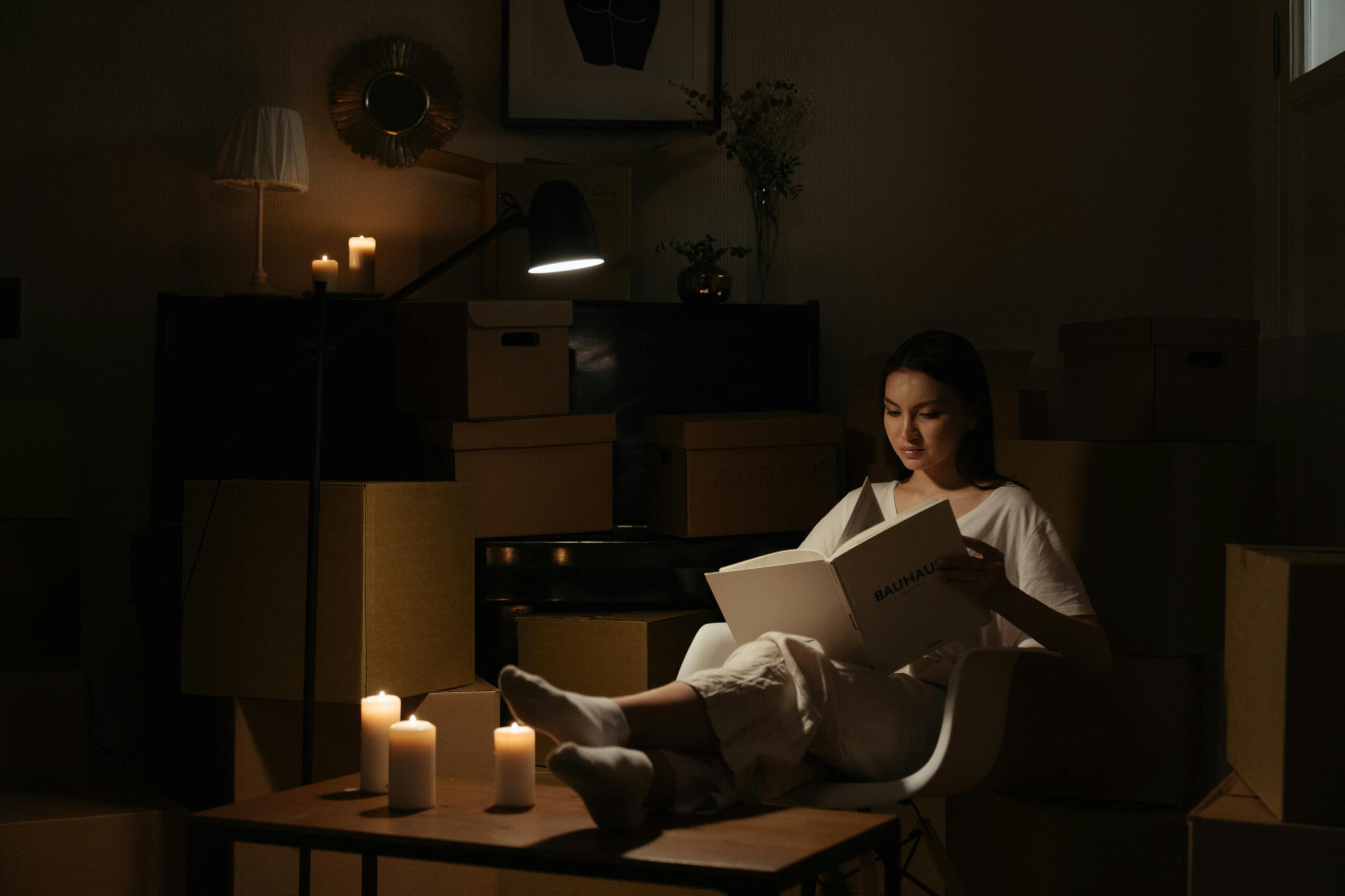 Woman reading a book by candlelight