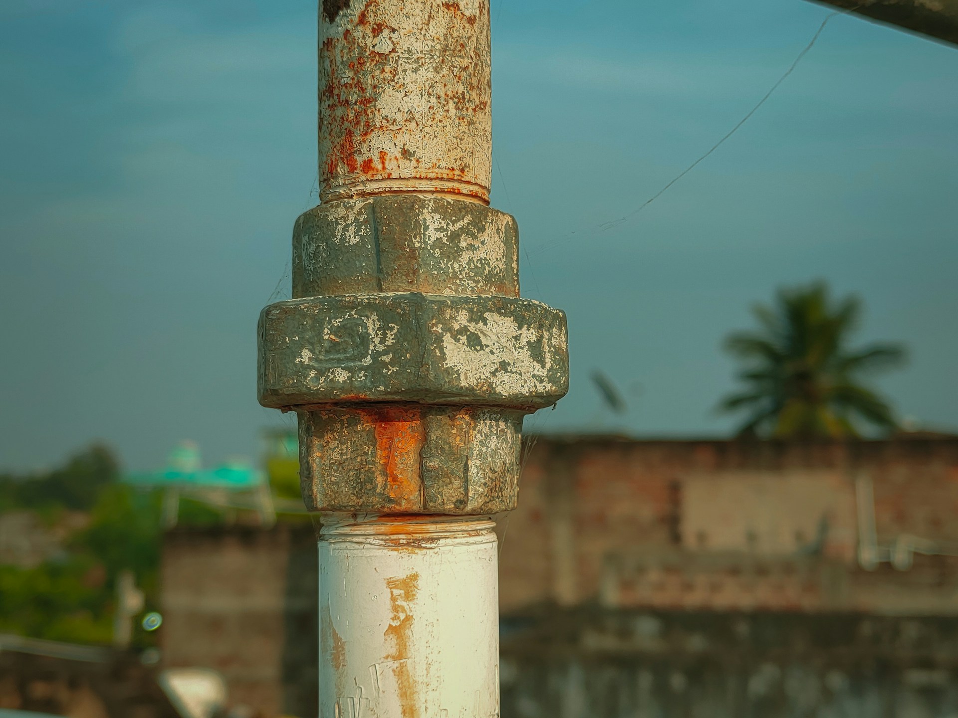 Rusty pipe, rusty nut, blue sky, chipping paint