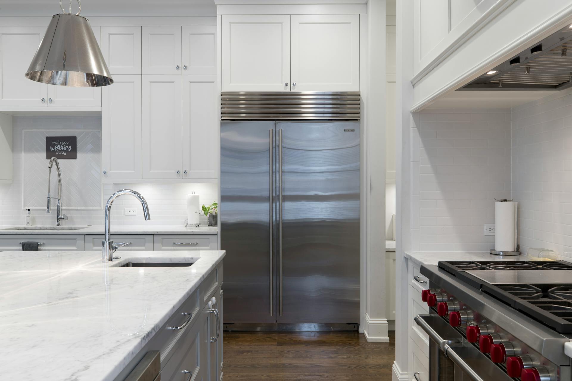 A silver fridge in a white kitchen