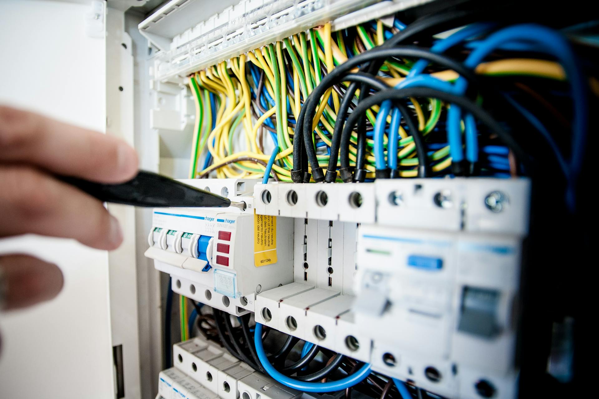Electrician fixing an open switchboard